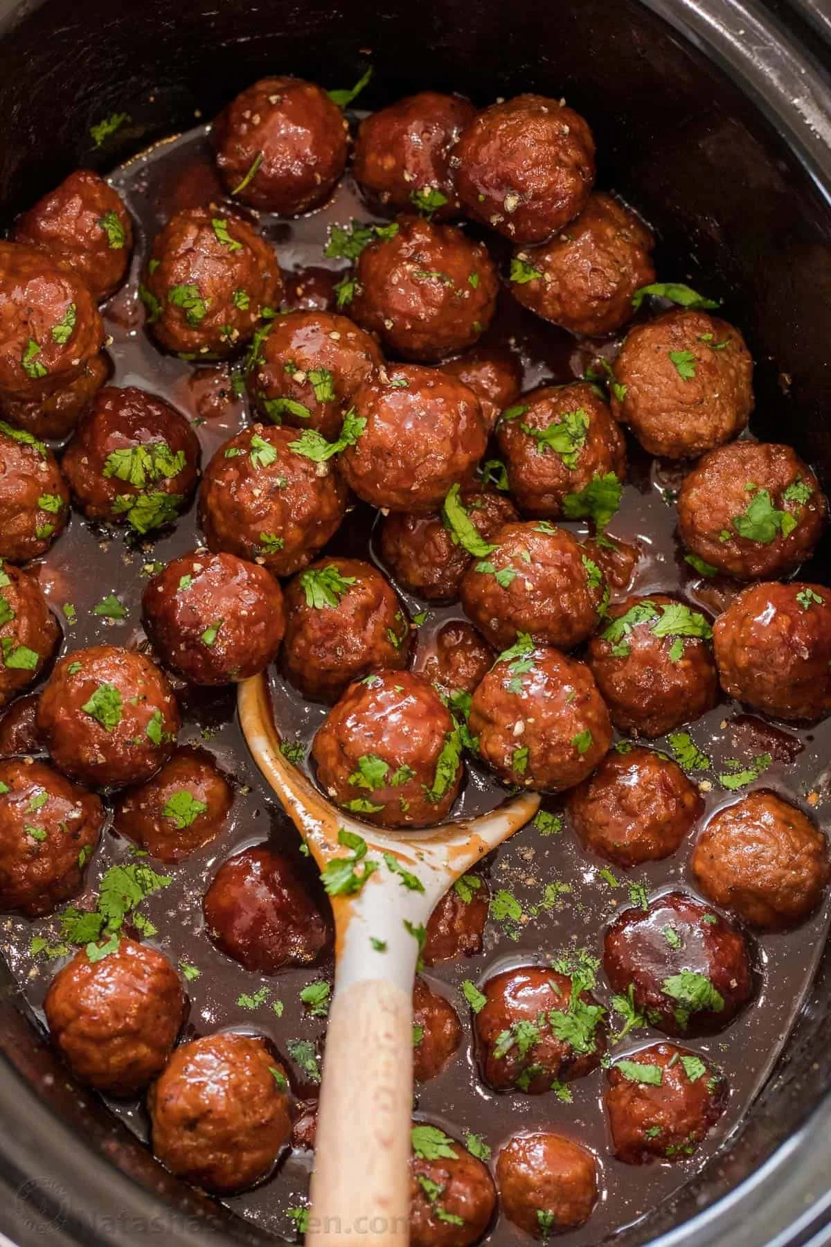 Plate of grape jelly meatballs served with toothpicks and garnished