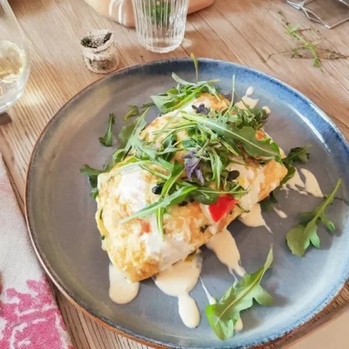 Gourmet omelette with fresh herbs and creamy goat cheese on a plate