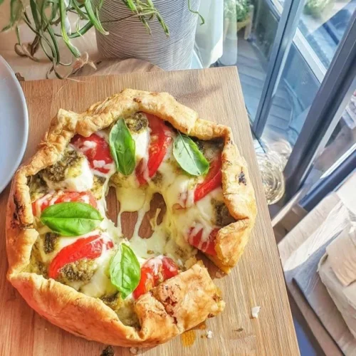 Delicious Sun Tart with Pesto and Mozzarella garnished with fresh herbs