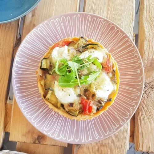 Delicious grilled vegetable and goat cheese tart served on a plate