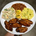Chicken wings, bbq baked beans, pasta salad and potato salad with deviled eggs