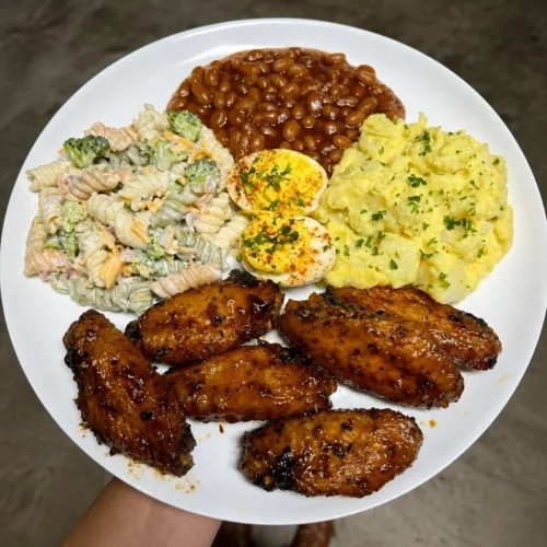 Chicken wings, bbq baked beans, pasta salad and potato salad with deviled eggs