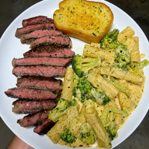 Juicy steak with pasta and garlic toast: flavoursome, hearty and satisfying 4 Juicy steak with pasta and garlic toast on a plate, ready to enjoy