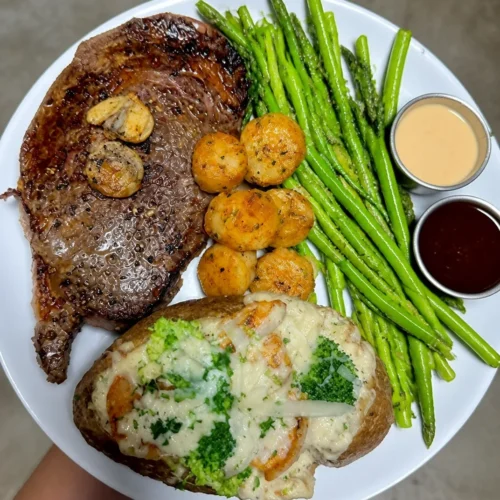 Protein-Packed Ribeye, Shrimp and Broccoli Alfredo on a Loaded Baked Potato Plate 3 Protein-packed Ribeye Alfredo dish with shrimp, broccoli, and loaded baked potato.