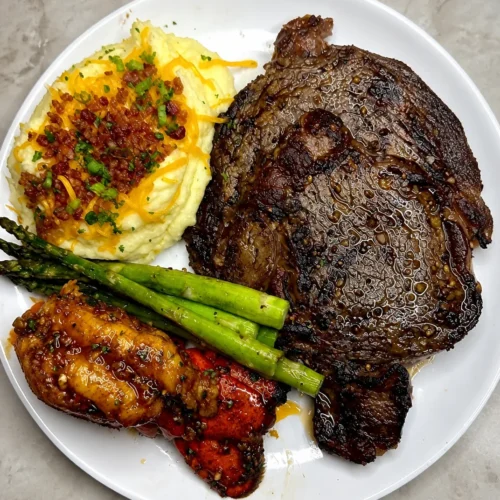 Steak and Lobster Dinner served with loaded mashed potatoes on a lavish table