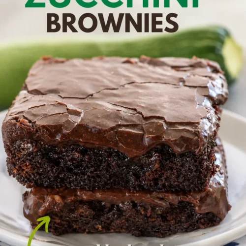 Delicious zucchini brownies topped with chocolate drizzles on a plate